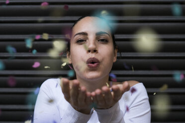 Young woman blowing confetti - KKAF00655