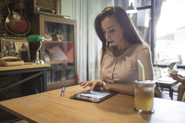Frau benutzt ein Tablet in einem Cafe - MOMF00037