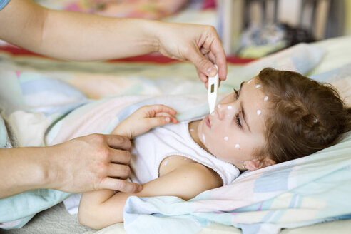 Mädchen mit Windpocken im Bett liegend mit Fieberthermometer - HAPF01432