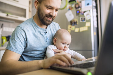 Vater mit kleinem Sohn benutzt Laptop zu Hause - HAPF01436