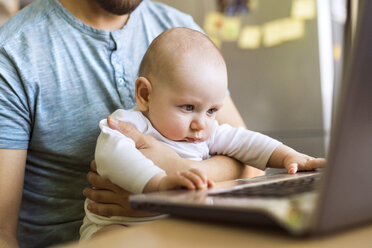 Vater mit kleinem Sohn benutzt Laptop zu Hause - HAPF01440