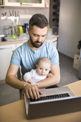 Father with baby son using laptop at home - HAPF01442