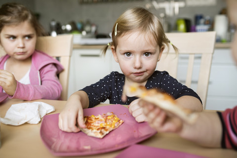 Kleine Mädchen essen zu Hause Pizza, lizenzfreies Stockfoto