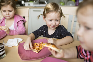 Kleine Mädchen essen zu Hause Pizza - HAPF01444