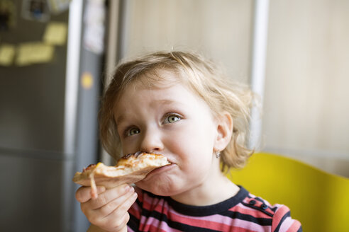 Little girl at home eating slice of pizza - HAPF01445