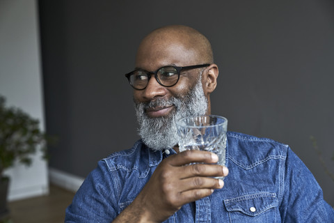 Mature man holding glass of water stock photo