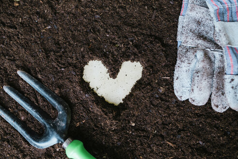 Herzform aus Gartenerde, Gartenwerkzeug und Handschuhen - GEMF01576