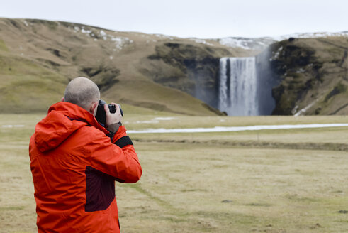 Iceland, photographer at Skogafoss waterfall - RAEF01821