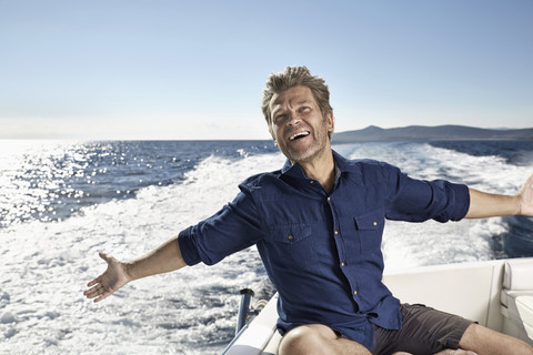 Portrait of happy mature man on his motor yacht stock photo