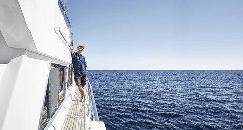 Älterer Mann auf seiner Motoryacht, lizenzfreies Stockfoto