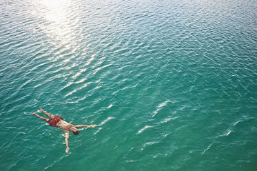 Mature man floating in emerald water - PDF01126