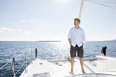 Mature man standing on sailing boat - PDF01131