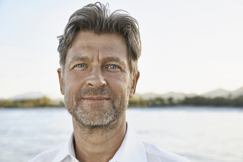 Portrait of smiling mature man with stubble in front of the sea - PDF01147