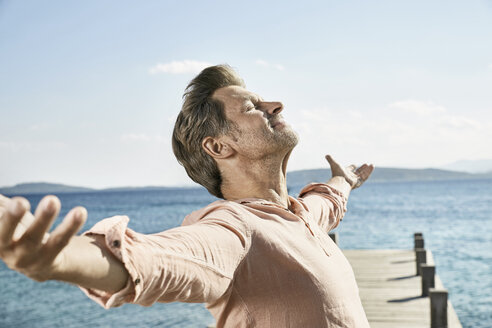 Man on jetty enjoying sunlight - PDF01200