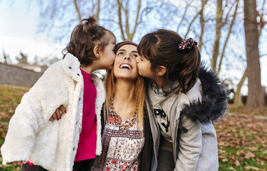 Happy mother kissed by her little daughters - MGOF03177