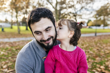 Kleines Mädchen küsst ihren glücklichen Vater im herbstlichen Park - MGOF03188