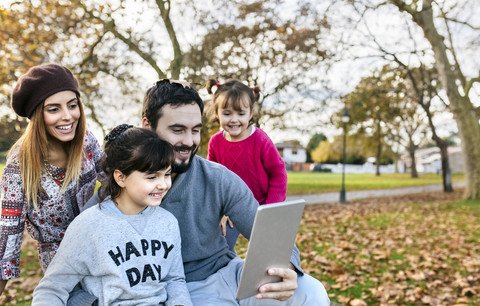 Familie mit Tablet im herbstlichen Park, lizenzfreies Stockfoto