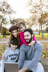 Family with tablet in autumnal park - MGOF03192