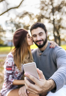 Paar macht Selfie mit Smartphone in herbstlichem Park, Nahaufnahme - MGOF03198
