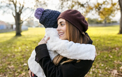 Happy mother embracing her little daughter in autumnal park - MGOF03204