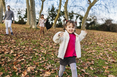 Porträt eines glücklichen kleinen Mädchens, das auf einem Hügel im Herbst läuft - MGOF03211