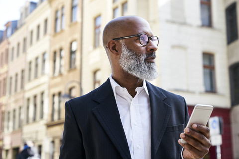 Älterer Geschäftsmann mit Smartphone, lizenzfreies Stockfoto