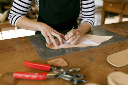 Close-up of shoemaker working on template in her workshop - VABF01299