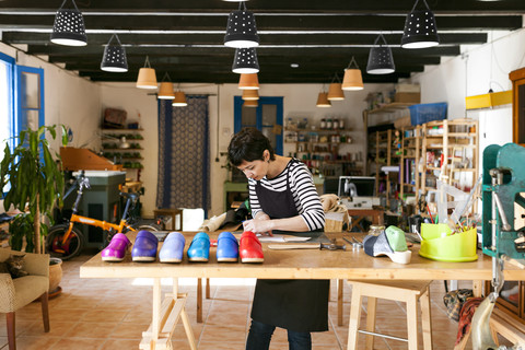 Holzschuhmacherin bei der Arbeit in ihrer Werkstatt, lizenzfreies Stockfoto