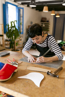 Schuhmacherin bei der Arbeit an einer Vorlage in ihrer Werkstatt - VABF01304