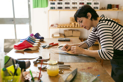 Schuhmacherin bei der Arbeit an einer Vorlage in ihrer Werkstatt - VABF01306