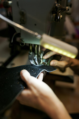 Close-up of shoemaker working on sewing machine stock photo