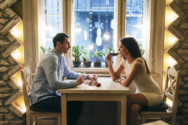 Junges Paar trinkt Wein in einem Restaurant am Valentinstag - MOMF00083