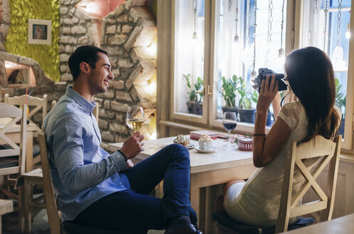 Junges Paar macht Sofortfotos in einem Restaurant - MOMF00086