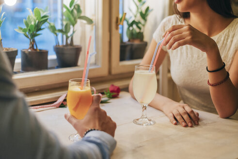 Junges Paar mit Getränken in einem Restaurant, Teilansicht - MOMF00087