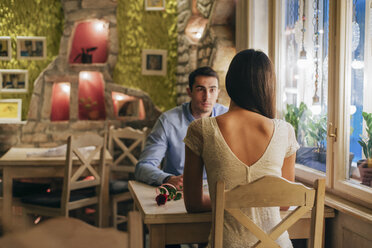 Rückenansicht einer jungen Frau, die von Angesicht zu Angesicht mit ihrem Freund an einem Tisch in einem Restaurant sitzt - MOMF00090