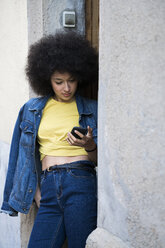 Junge Frau schaut auf ihr Mobiltelefon - KKAF00698