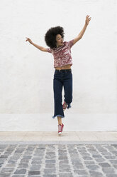 Junge Frau springt in die Luft - KKAF00703