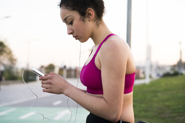 Young jogger with earphoes and cell phone - KKAF00715