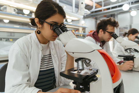 Laboranten, die Mikroskope im Labor benutzen, lizenzfreies Stockfoto