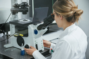 Laboratory technician using microscope in lab - ZEDF00579