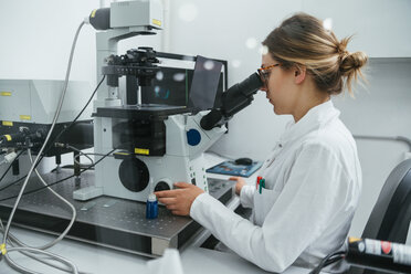 Laboratory technician using microscope in lab - ZEDF00582