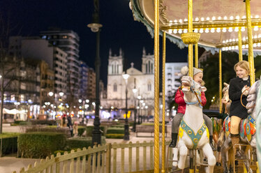 Two girls riding a Christmas carousel - MGOF03213