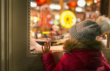 Mädchen schaut in ein Weihnachtsschaufenster - MGOF03214