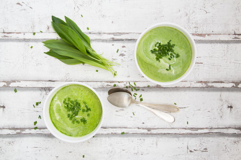 Two bowls of ramson soup garnished with chives and cream stock photo