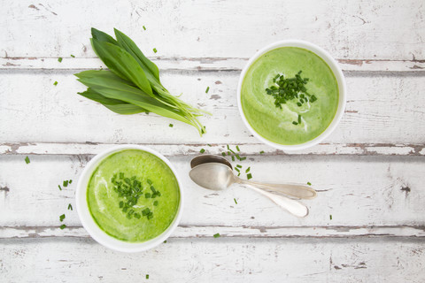 Zwei Schalen Bärlauch-Suppe mit Schnittlauch und Sahne garniert, lizenzfreies Stockfoto