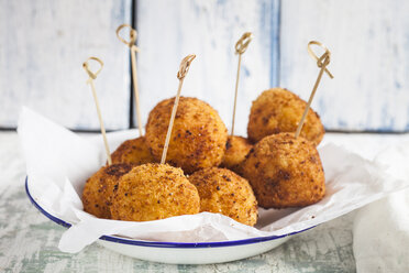 Arancini mit Spießchen auf einem Teller - SBDF03185