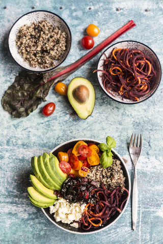 Lunch bowl of quinoa tricolore, chard, avocado, carrot spaghetti, tomatoes and feta stock photo