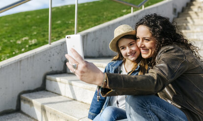 Glückliche Mutter und Tochter machen ein Selfie auf der Treppe - MGOF03217