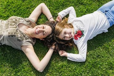 Mother and daughter having fun lying in the grass - MGOF03220
