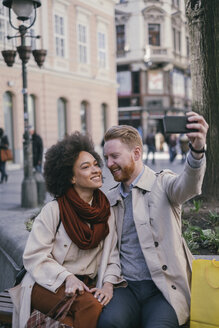 Ein glückliches Paar macht ein Selfie in der Stadt - MOMF00148